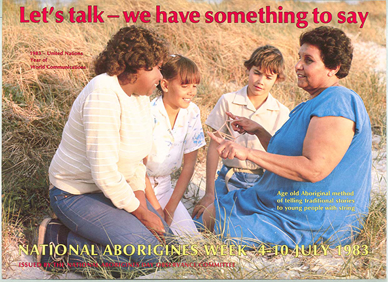 Colour ink on paper. Title: 'Let's Talk - We Have Something To Say’. Features a photograph of an Aboriginal woman telling a story, using string, to three young Aboriginal children; printed in red text.