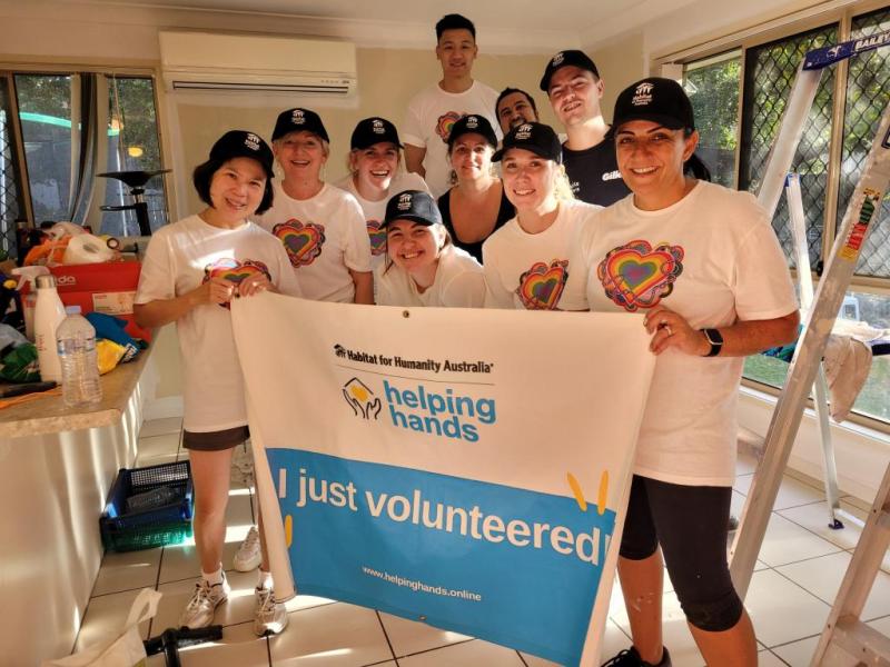 Group of people behind a "I just volunteered" banner