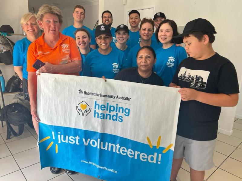 Group of people behind a "I just volunteered" banner