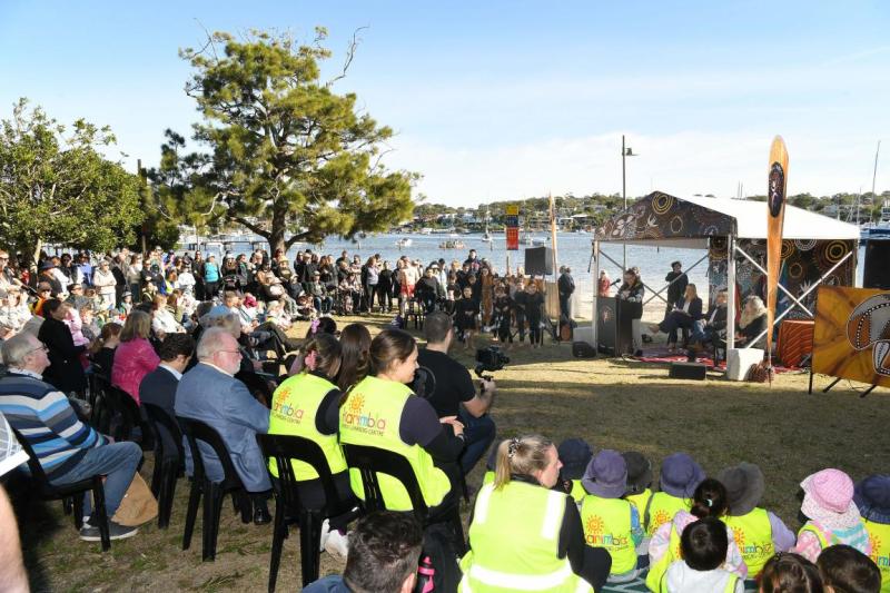 A crowd sits watching a ceremony