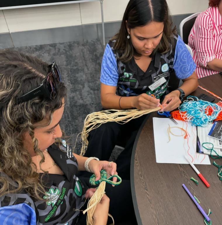 Two girls work on art at a table