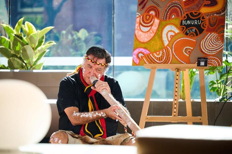 a man plays a didgeridoo