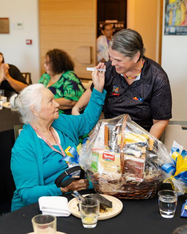 An older lady appreciates another lady bringing food to the table
