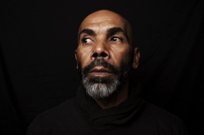 A mans face emerges into the light