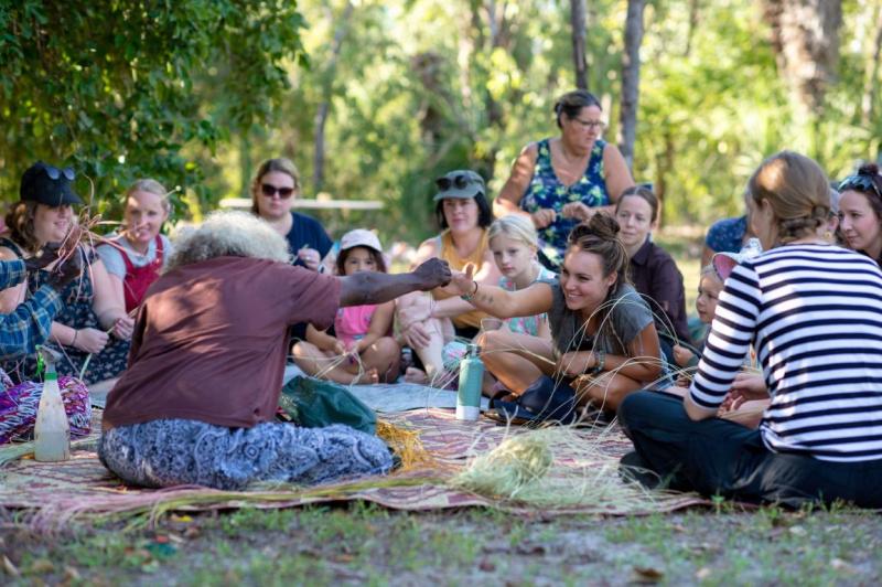 People sit on rugs in nature for picnic