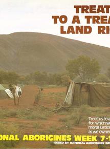 A colour poster issued to promote NAIDOC week in 1980. Features a photograph of a camp site with humpies (or gunyahs) with Uluru (Ayers Rock) in the background.